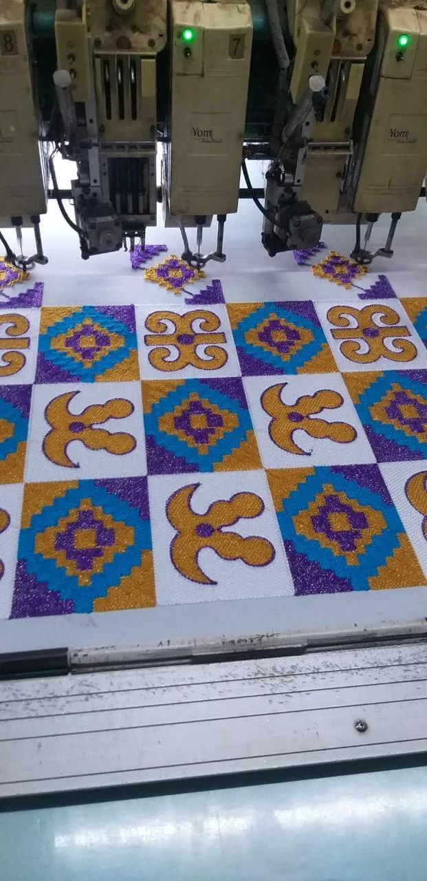 Gold and purple Adinkra-motif embroidery in progress